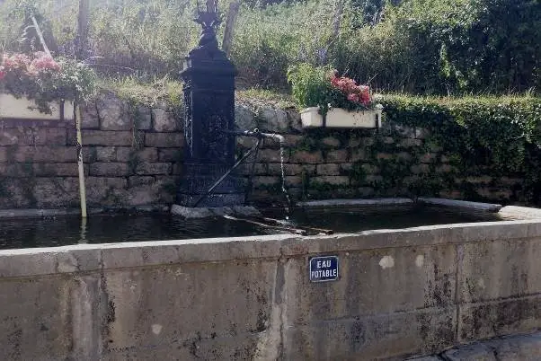 Faire le plein des bidons à une fontaine dans le Jura 