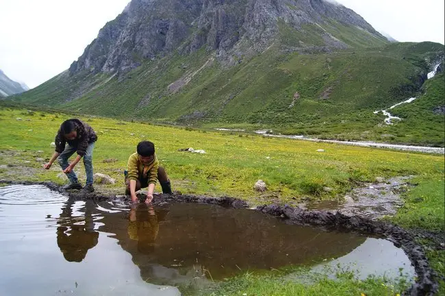 des enfants construisent un barrage au Mont Gongga en Chine