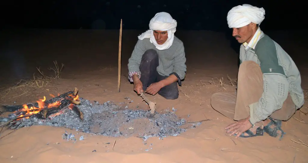 Les 2 chameliers préparent le feu pour la cuisson du pain du désert au Maroc