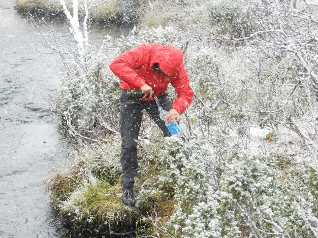 Remplissage des gourdes en conditions hivernales trek en Laponie