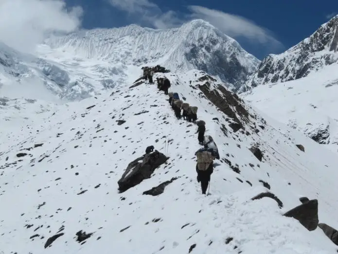 12 : Les porteurs sur la moraine menant au camp de base