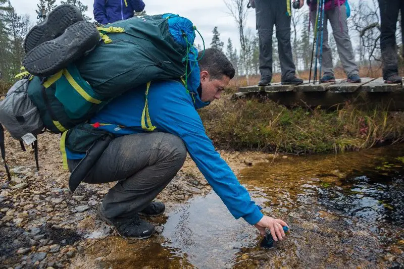 Fred remplit les gourdes dans une rivière