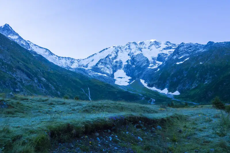 le soleil arrive seulement sur le haut du glacier pendant le trail dans les contamines dans les Alpes