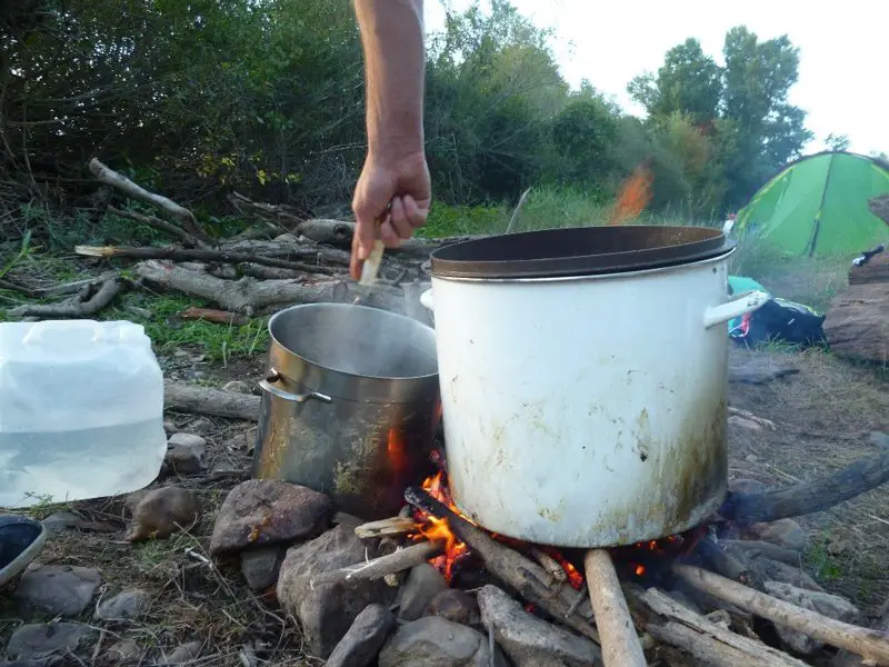Préparation du repas sur le feu de bois durant le bivouac de la descente de la loire en canoe