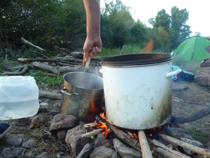 Préparation du repas sur le feu de bois durant le bivouac de la descente de la loire en canoe Préparation du repas sur le feu de bois durant le bivouac de la descente de la loire en canoe