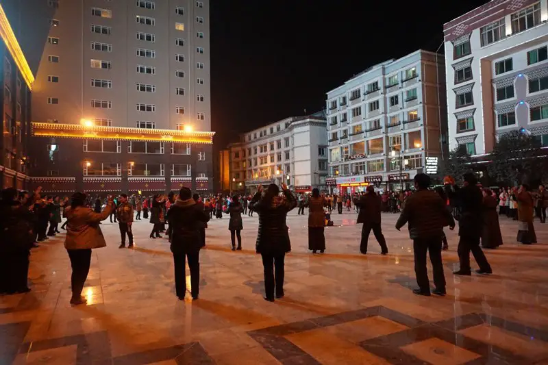 foule qui danse sur la place centrale à Yajiang - G318