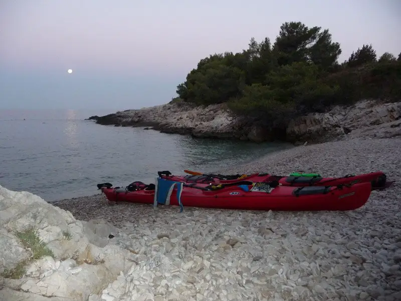 Crique et plage de galets face au coucher de soleil