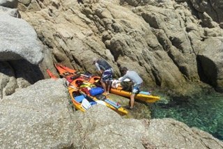 Accostage sur un rocher, kayak de mer en Corse