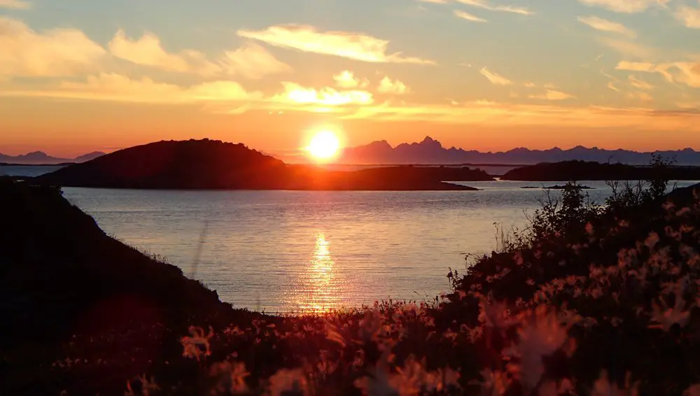 Soleil de minuit. Au loin les Lofoten, kayak en Norvège