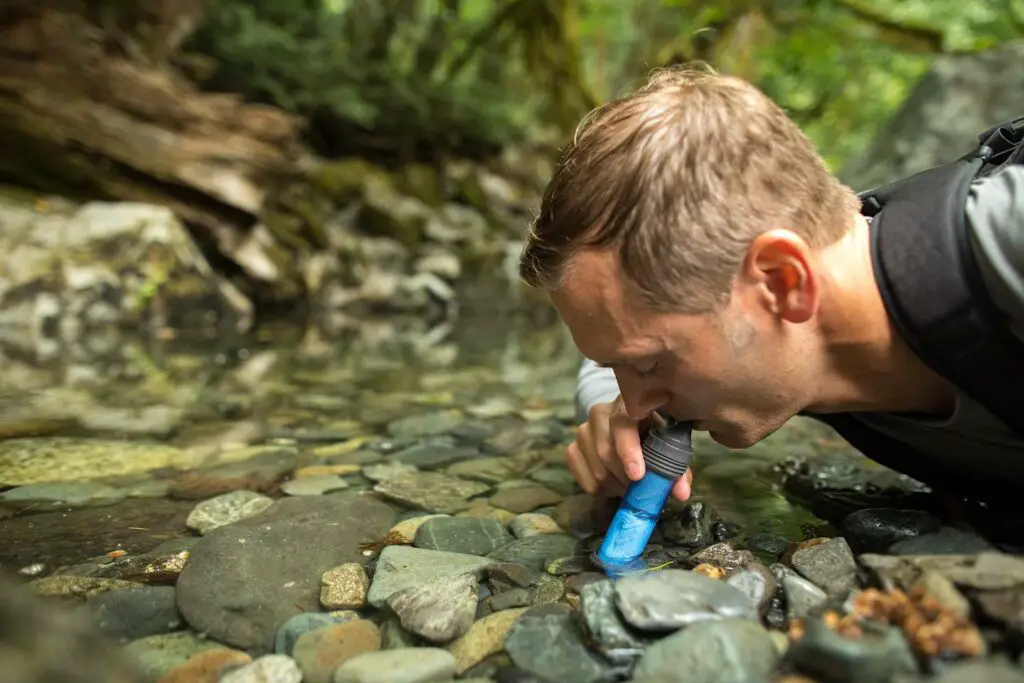 boire avec une paille lifestraw pour filter l'eau