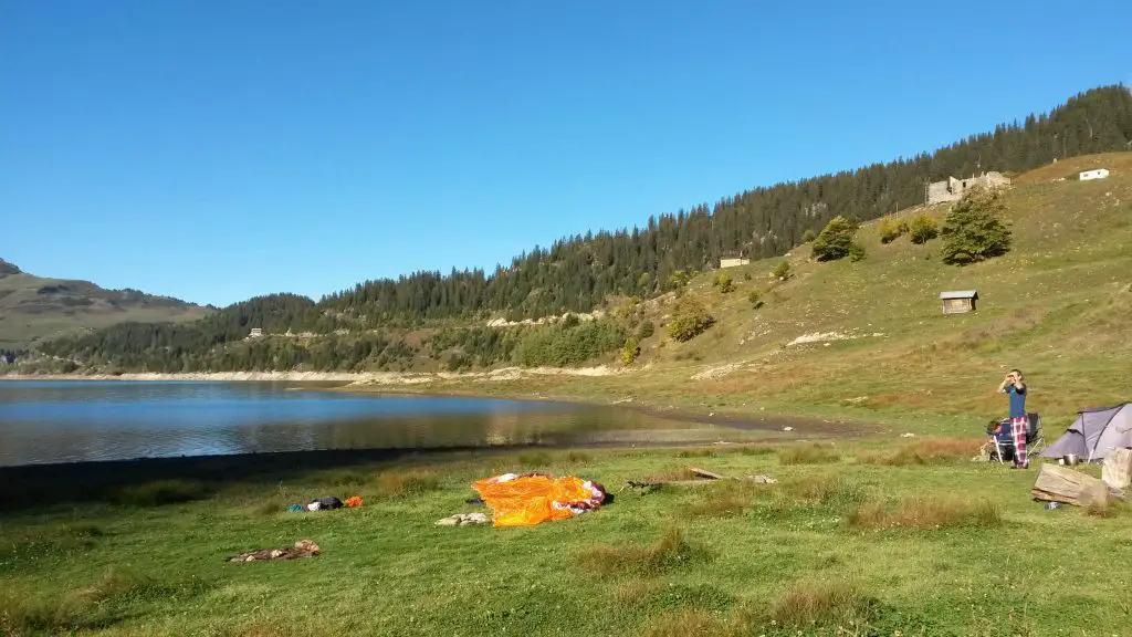 Atterrissage au bord du lac Roselend près de deux campeurs allemands dans le Beaufortain lors du bivouac en parapente Atterrissage au bord du lac Roselend près de deux campeurs allemands dans le Beaufortain lors du bivouac en parapente