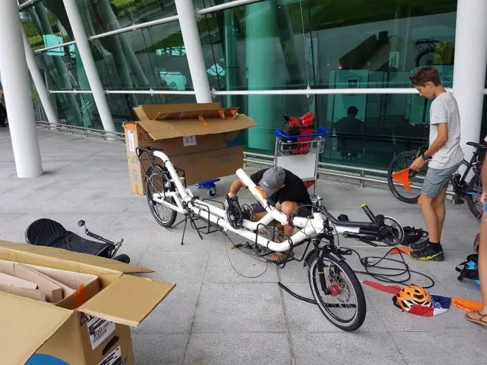 Séance remontage de vélos devant l’aéroport de Porto durant nos vacances à vélo en famille
