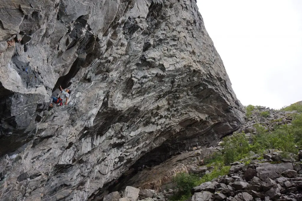 Côme en train de grimper dans un 7c sur la falaise d'escalade de Flatanger en Norvege