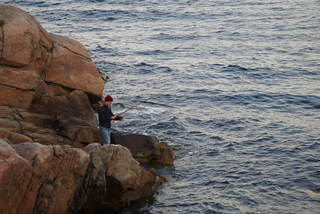 Côme en train de pêcher à Flatanger après une journée de grimpe en Norvège