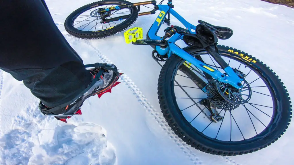 crampons au pied pour porter mon VTT sur la neige glacée