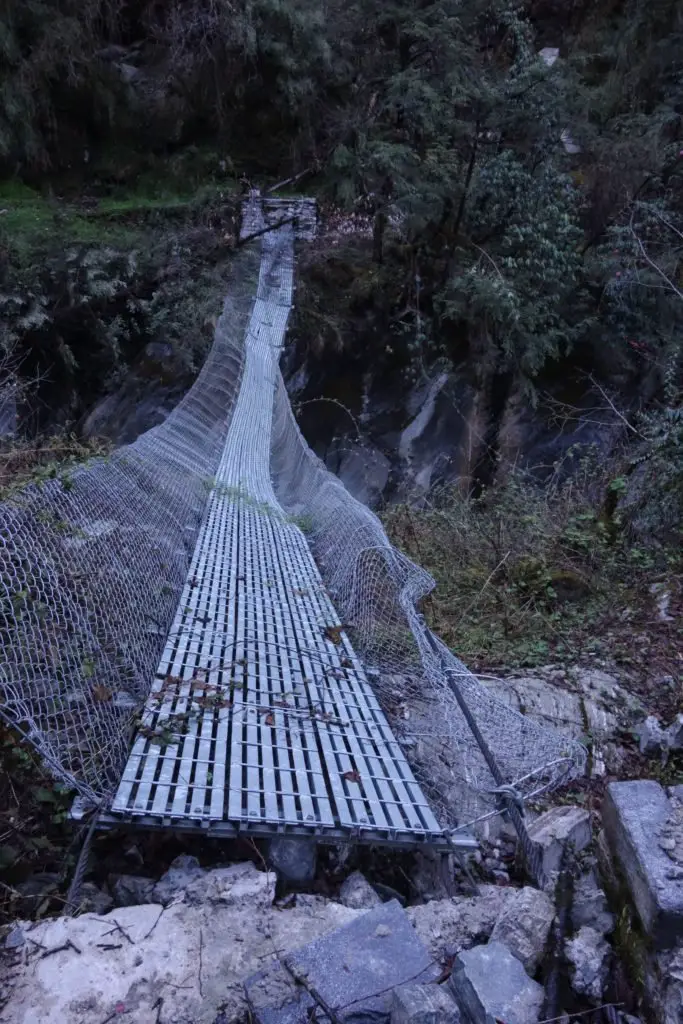 Pont en métal périlleux pour traverser la rivière au Népal