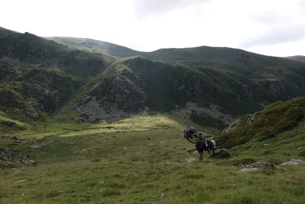 Becca portant son vélo en Bambou durant la traversée des Pyrénées