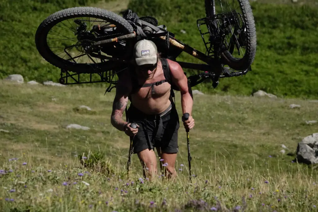 Léandre Deryckere portant son vélo en Bamboo sur les pentes des Pyrénées