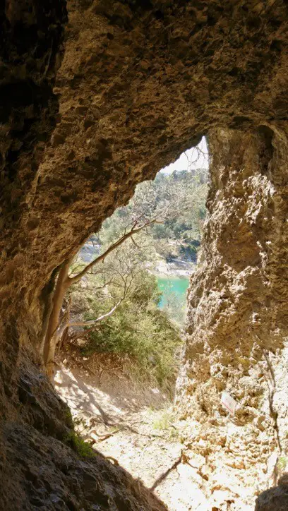 Vue du lac du Peiroou dans les Alpilles en traversant une falaise à travers un trou rocheux.