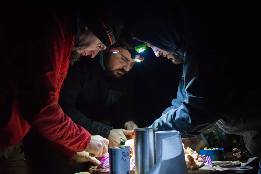 Préparation du repas à la frontale au bivouac après une journée de pêche à la mouche en Patagonie