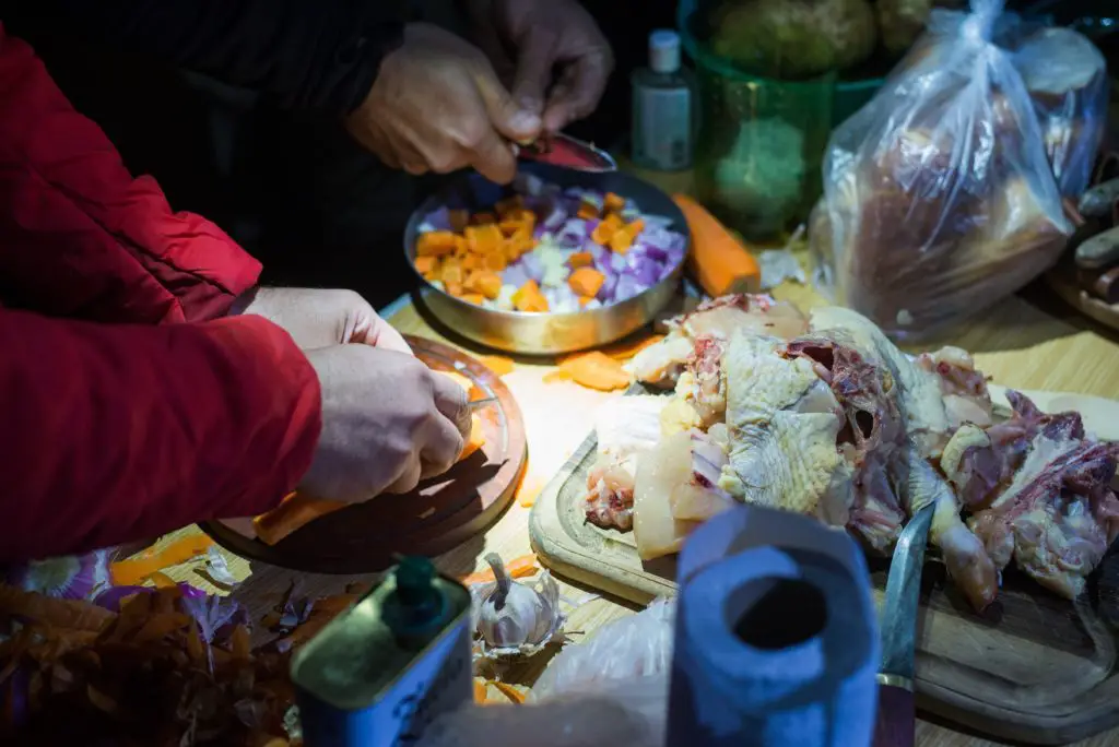 Mains de cuistot pour un repas argentin au feu de bois après une journée de pêche à la mouche en patagonie