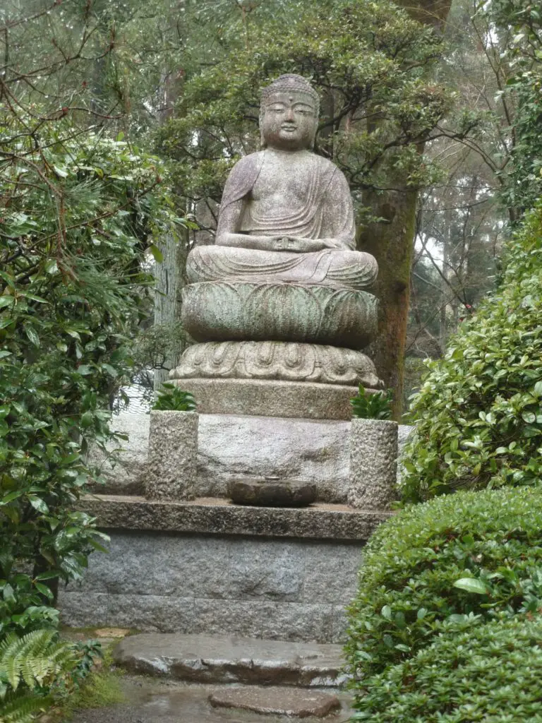 Boudha dans le parc entourant le Pavillon d’Or à Kyoto