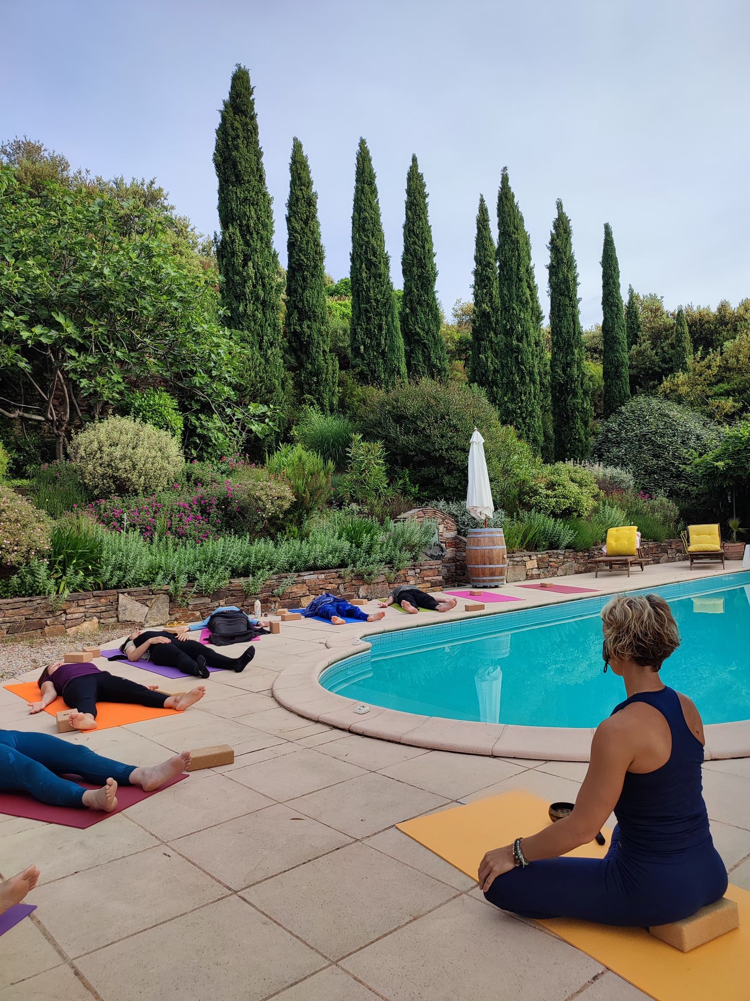 Asanas yoga au réveil autour de la piscine