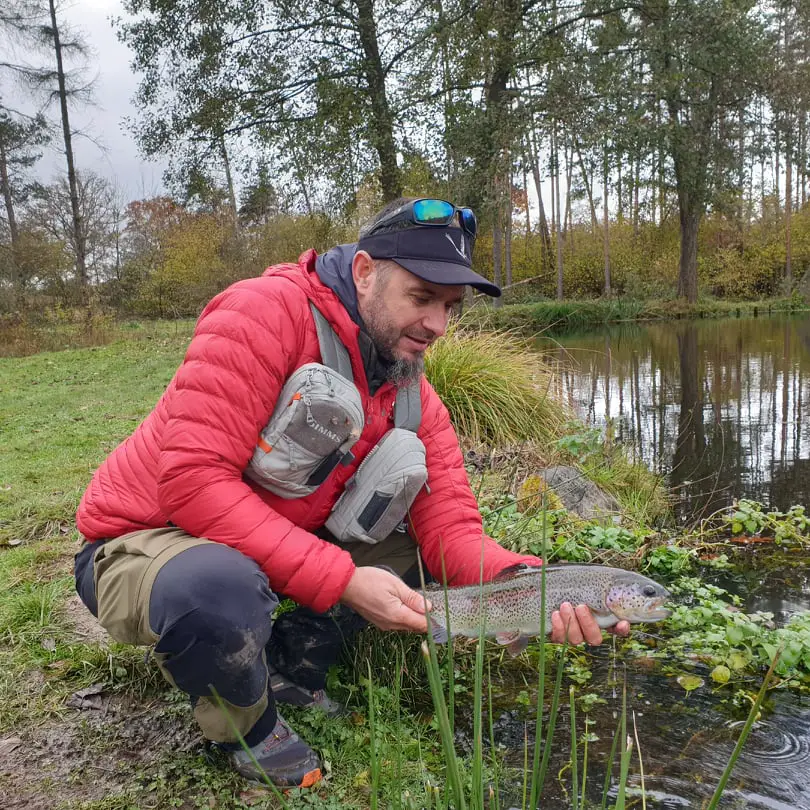 Remise à l'eau d'une truite lors d'un test à la pêche de la doudoune haglofs