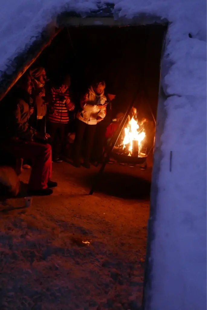grillade de saucisses au feu de bois sous un tipi en finlande
