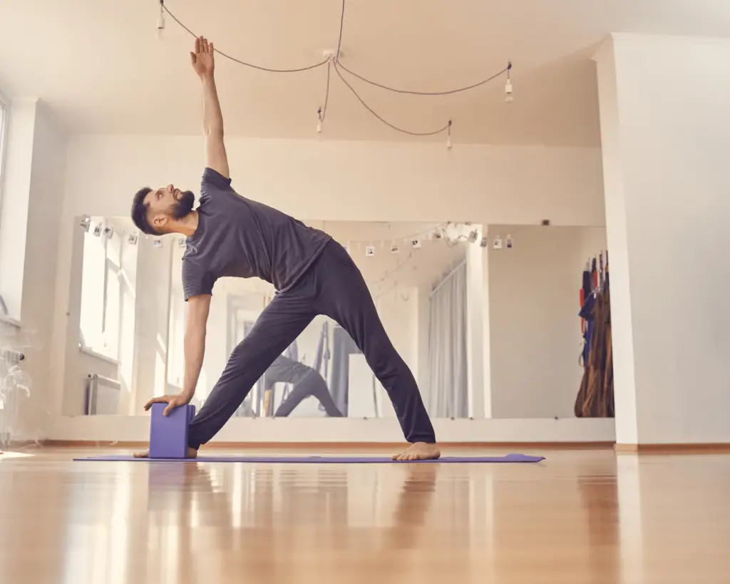 Trikonasana-posture du triangle avec brique de yoga