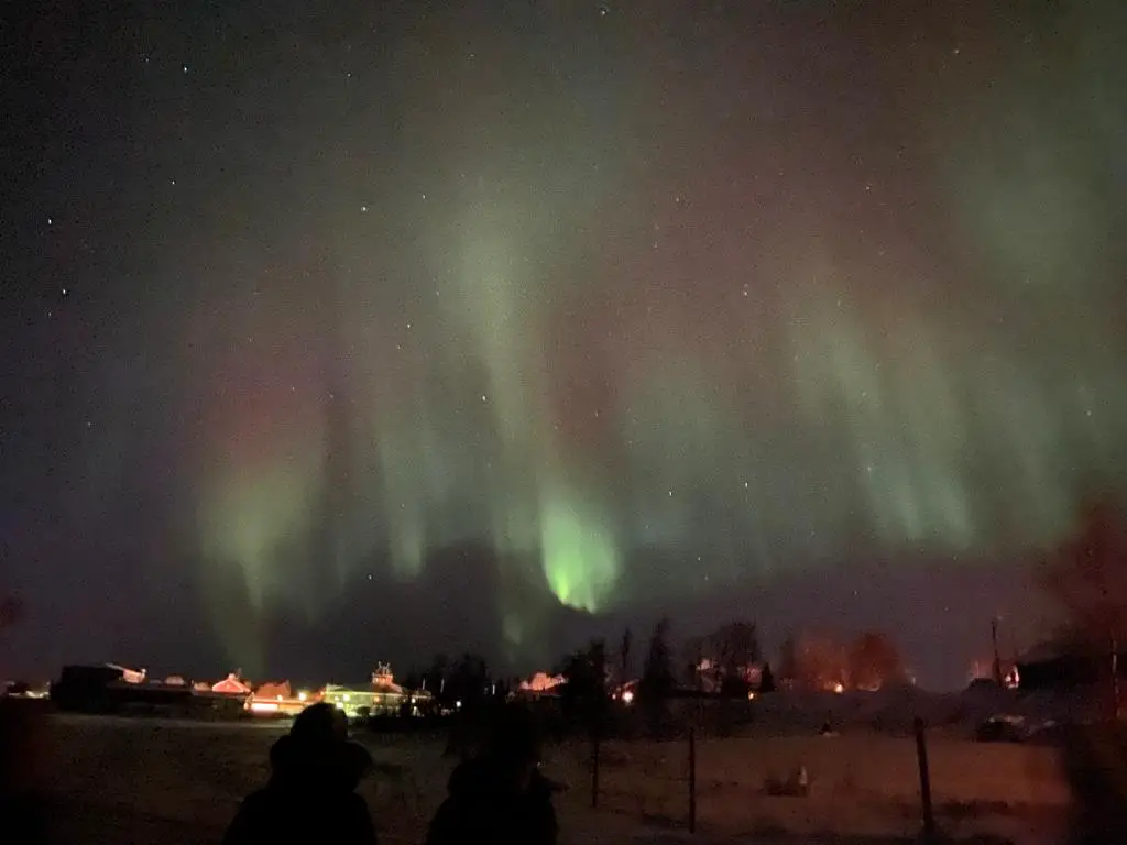 Aurores boreales danse de lumières dans le ciel entre vert et rose