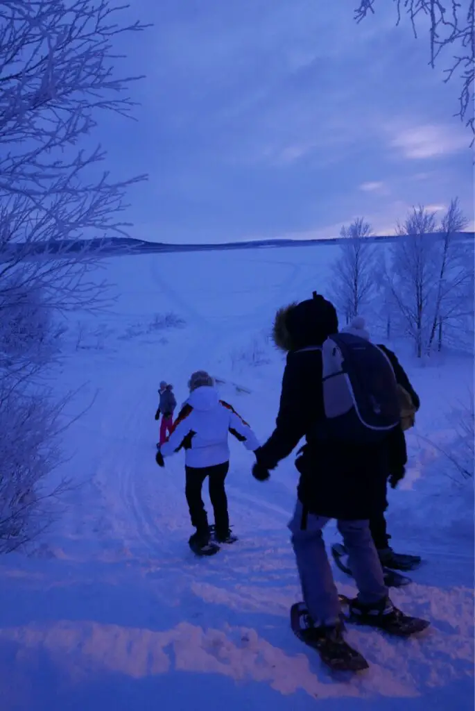 descente vers le lac de karesuando en suède en raquettes à neige