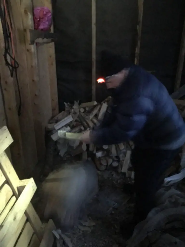 Gérard LONGUET coupant du bois pour chauffer le sauna en suède