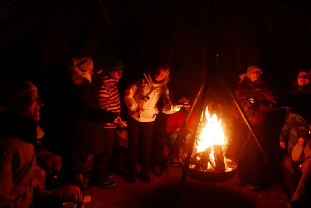 grillade de saucisse sous tipi en bois en finlande