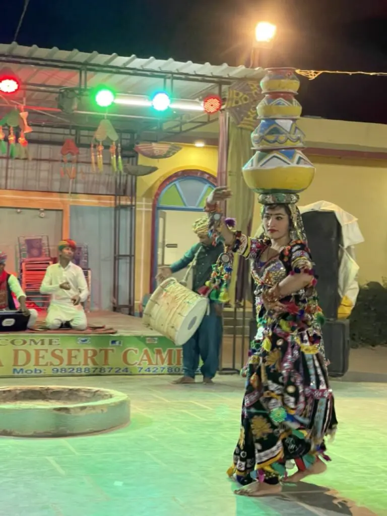 danseuse traditionnelle du rajasthan dans le désert de sam avec des pots sur la tete