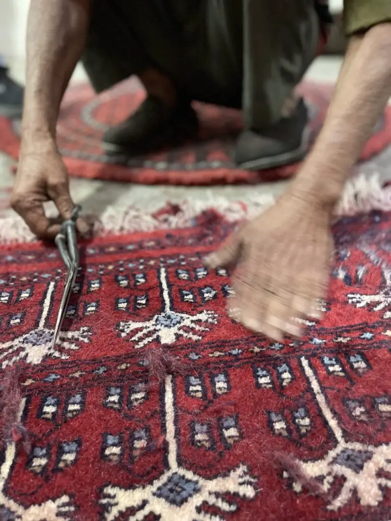 etape de finition au ciseau d'un tapis en laine en inde