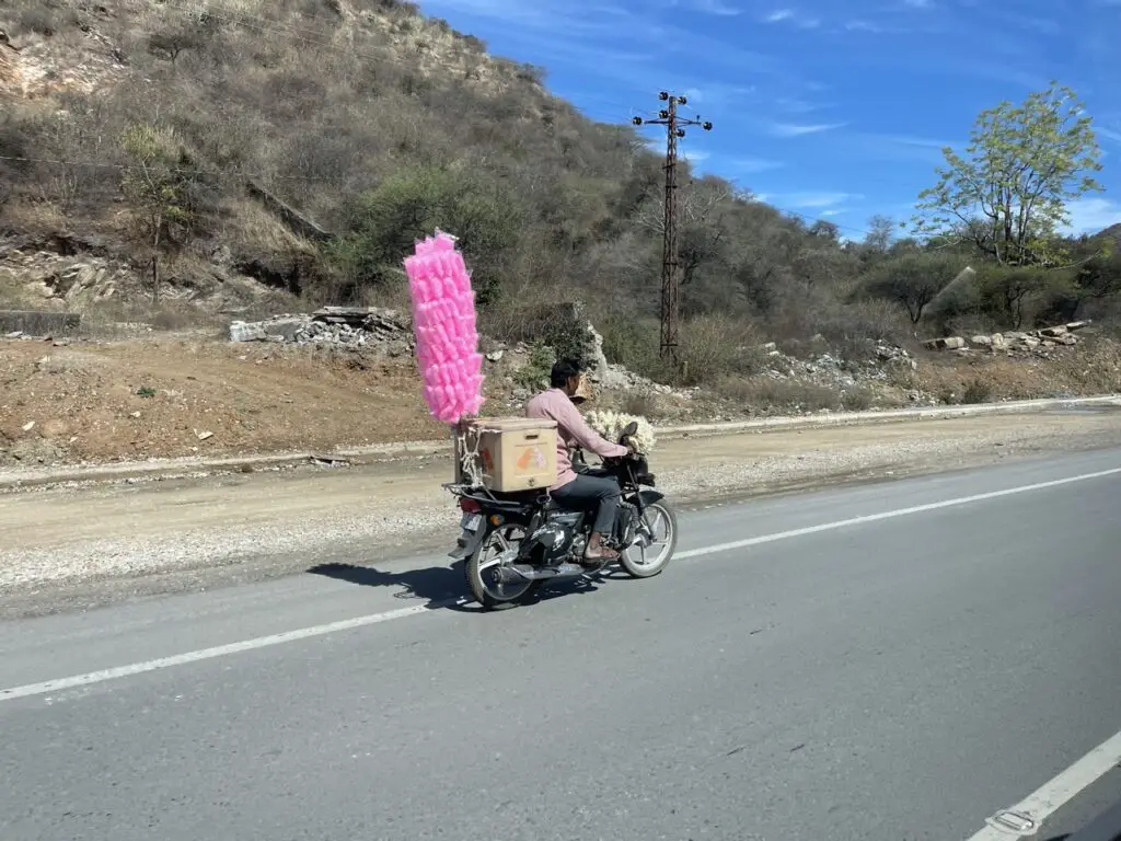 motard commerçant avec barbe à papa sur sa mobylette