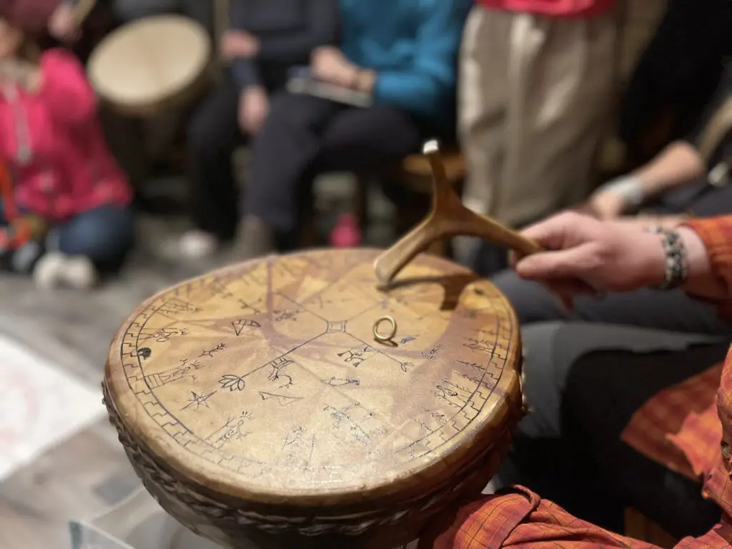etapes de divination au tambour SAMI ou Peter Fourbears Armstrand tape avec son marteau pour que l'anneau circule sur le tambour