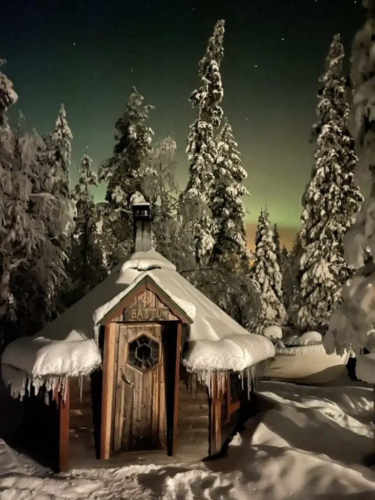 Aurore Boréale à Mellanstrom en laponie Suédoise devant le Bastu le sauna traditionnel suédois