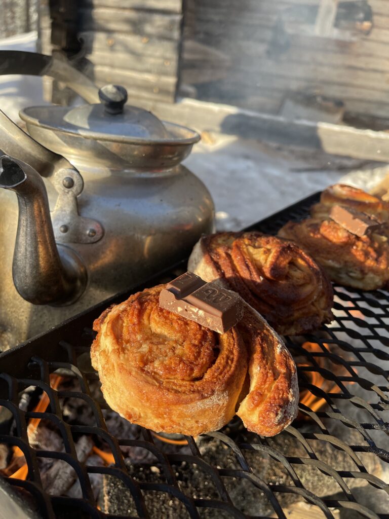 brioches à la cannelle réchauffées au feu de bois avec chocolat fondu en laponie suédoise