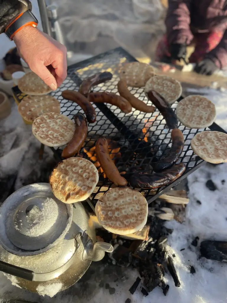 Grillade au feu de bois à la place au feu au bord du lac Makkaure pres de Mellanstrom en laponie suédoise