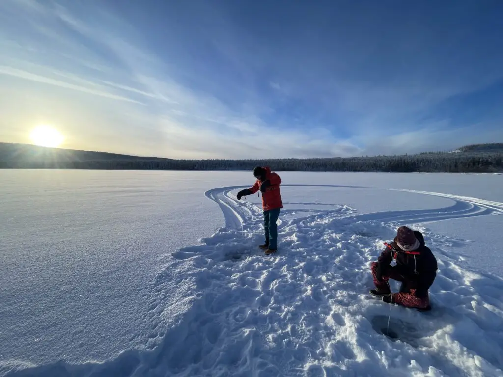 Pêche blanche sur lac gelé en laponie suédoise