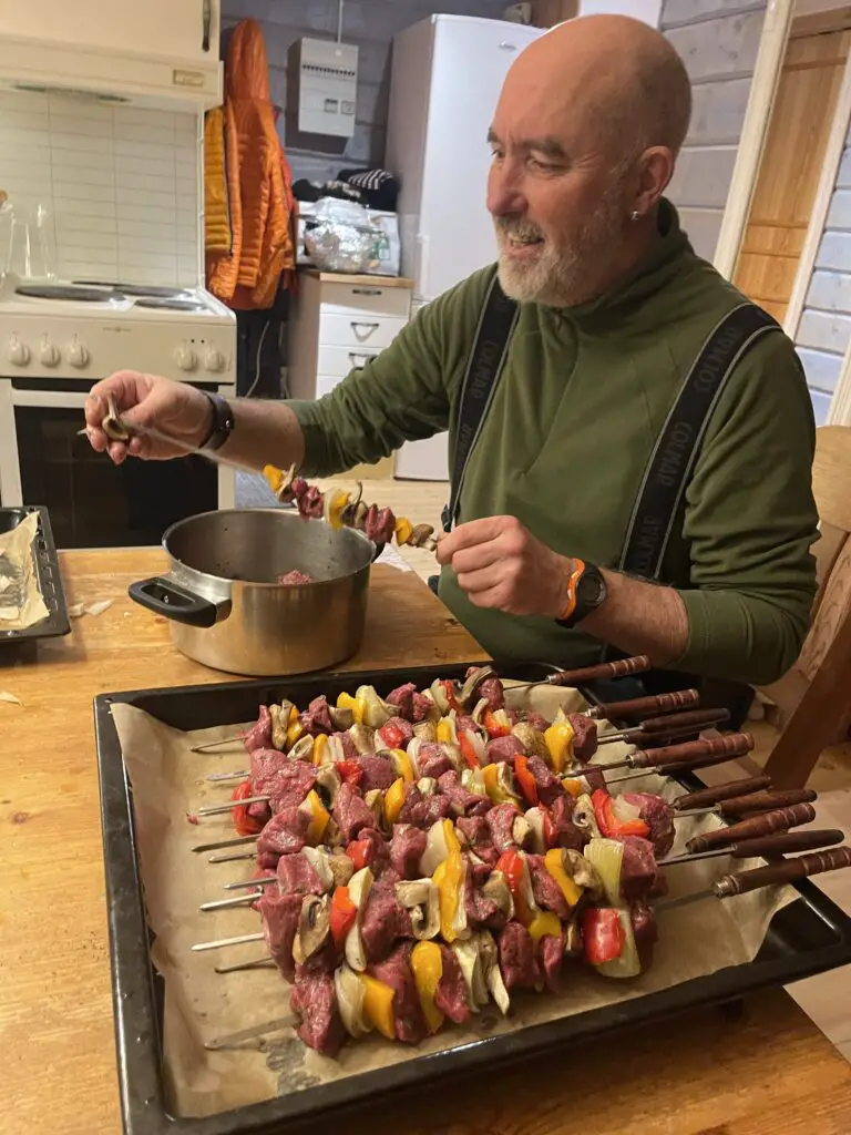 Robert BOUR préparant des brochettes à la viande d'élan en laponie