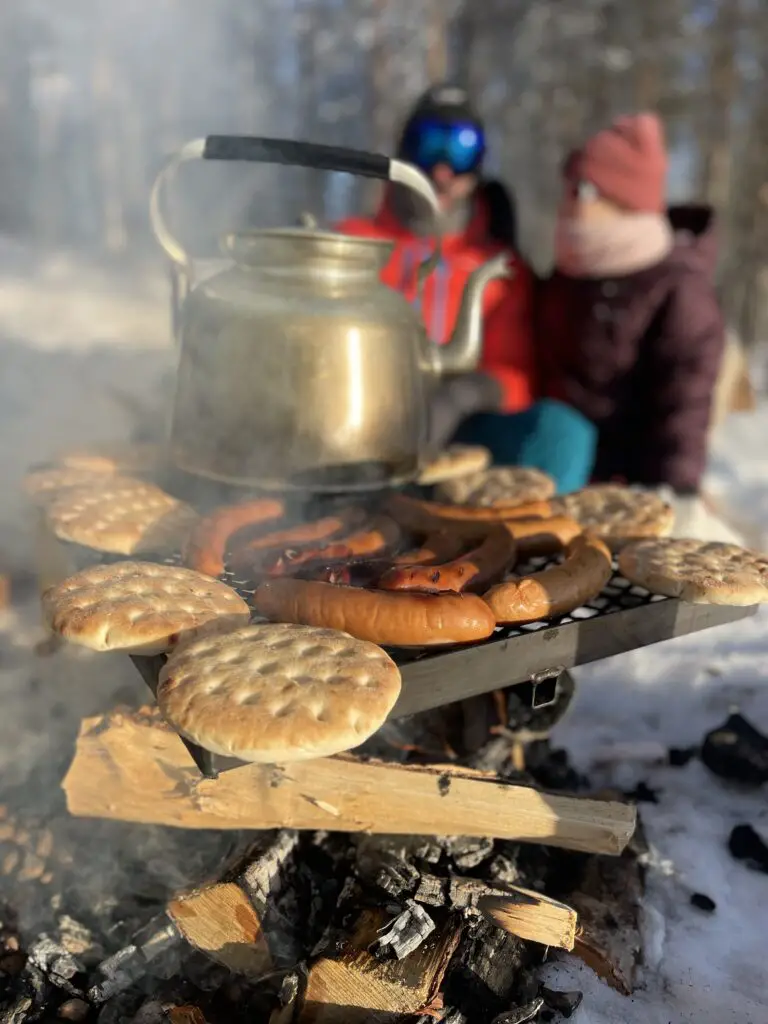 Saucisses de rennes grillées au feu de bois en pleine nature en laponie suédoise