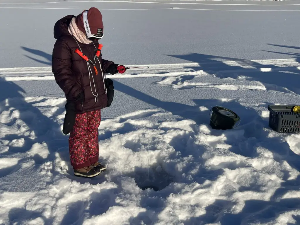 Victoire enfant de 9 ans découvre la pêche blanche en Laponie