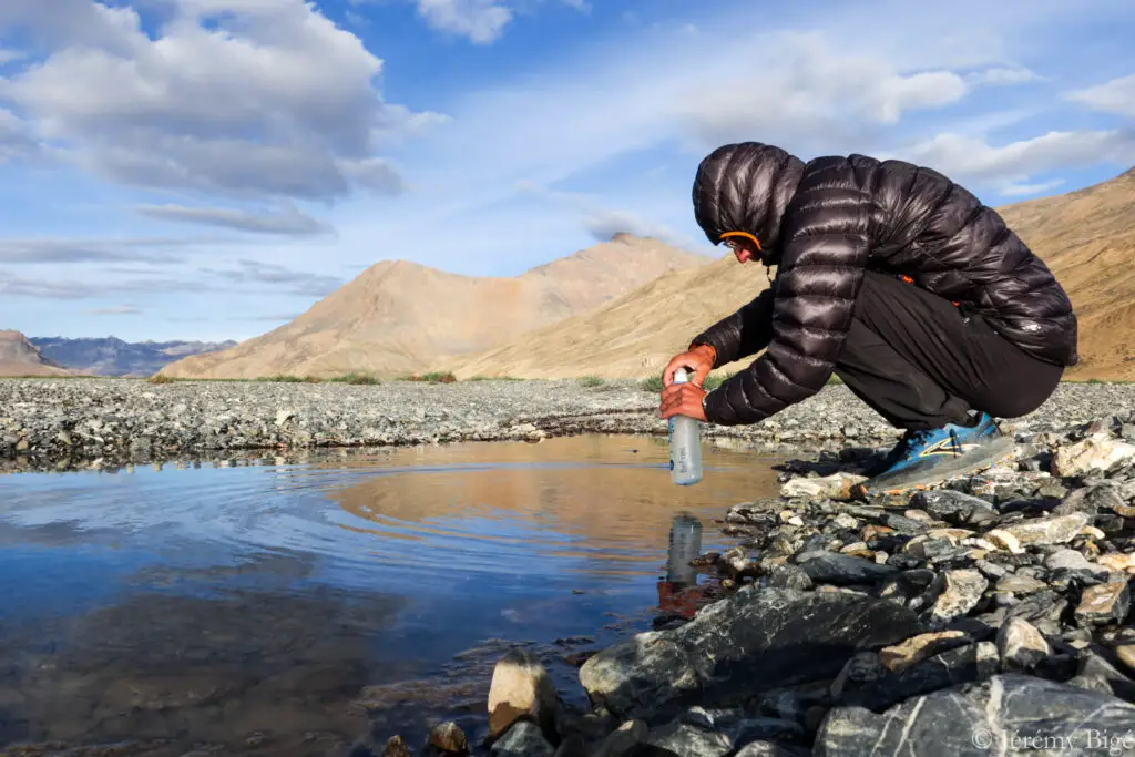 Filtrage de l'eau stagnante d'une flaque bienvenue après de nombreux kilomètres sans boire.