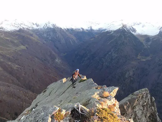 Le regard de Yoann capte les derniers rayons du soleil, sur fond de Pyrénées fraichement saupoudrées. activités plein air à Font Romeu avec escalade et alpinisme