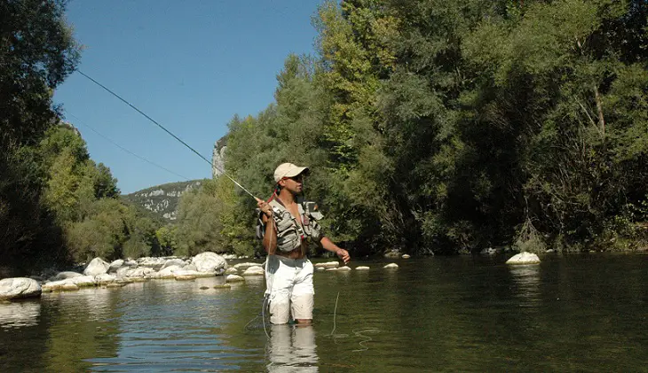 pêche à la mouche dans l'Hérault avec Olivier fouettant avec le Thaurac en fond de paysage